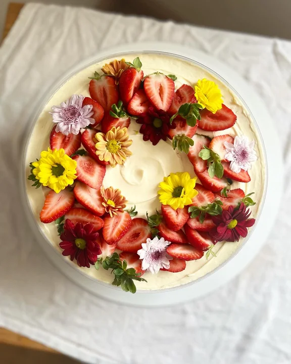 Bolo coberto de morangos e flores comestíveis