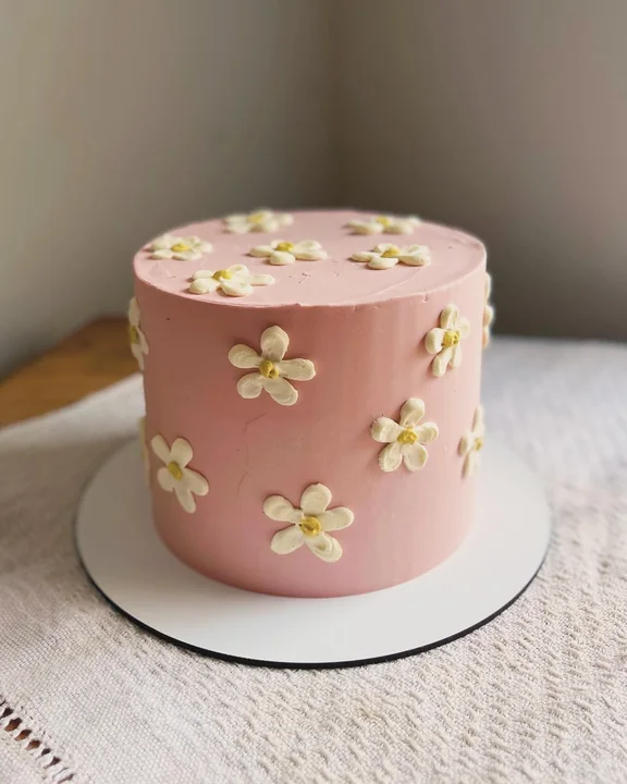 Bolo rosa com margaridas
