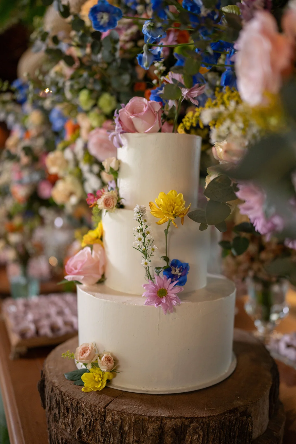 Bolo de casamento de três andares decorado com flores do campo